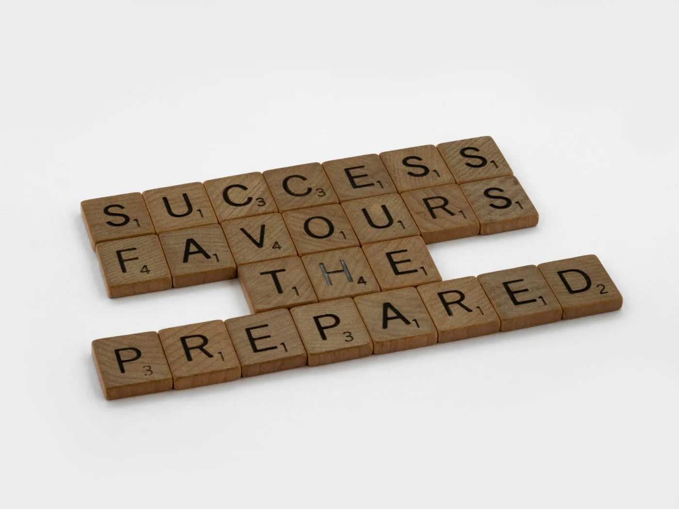 Scrabble tiles spelling out the sentence "Success favours the prepared"